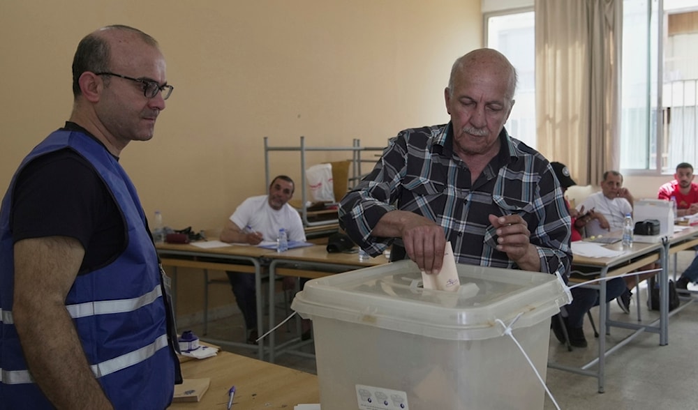 A man casts his vote as election observers monitor the process at a polling station during municipal elections in Beirut, Lebanon, Sunday, May 18, 2025. (AP)