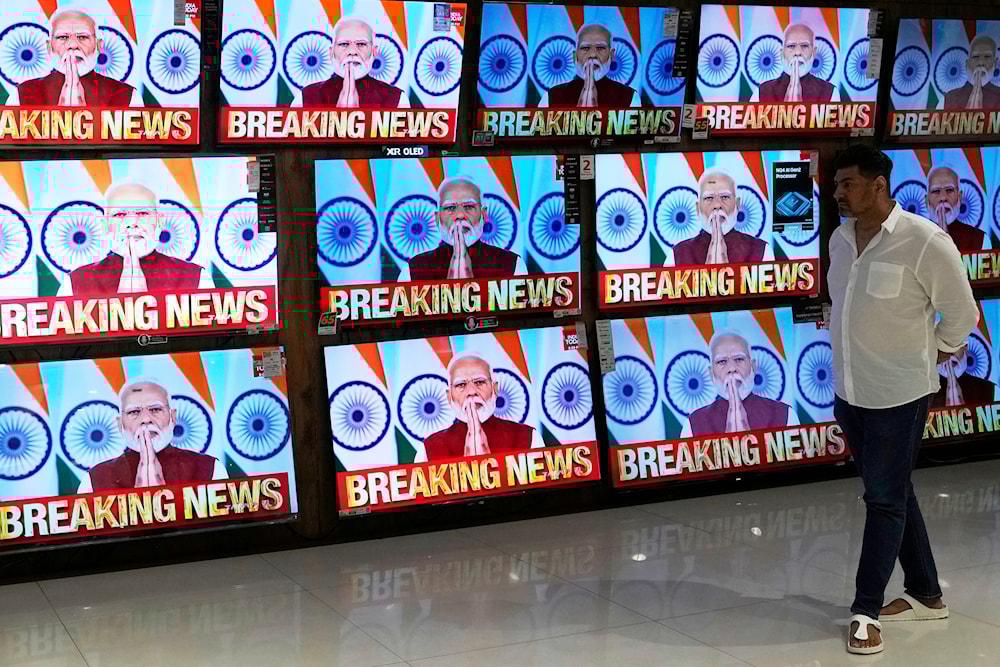 A man watches the live telecast of Indian Prime Minister Narendra Modi's speech on television screens at a shopping mall after 'Operation Sindoor' in Mumbai, India, Monday, May 12, 2025. (AP)