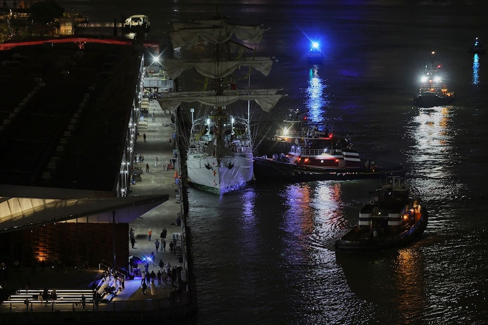 Tug boats assist the Cuauhtémoc, a masted Mexican Navy training ship, toward Pier 35 after it collided with the Brooklyn Bridge, Saturday, May 17, 2025, in New York. (AP)