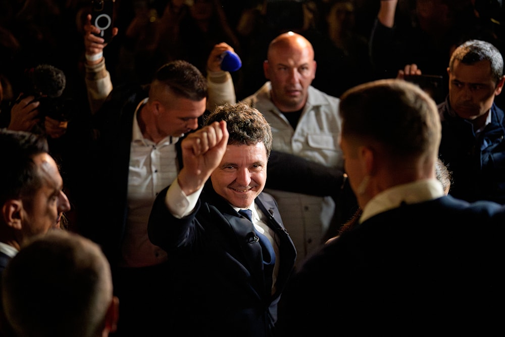 Presidential candidate Nicusor Dan, center, gestures after winning the second round of the country's presidential election redo in Bucharest, Romania, early Monday, May 19, 2025. (AP)