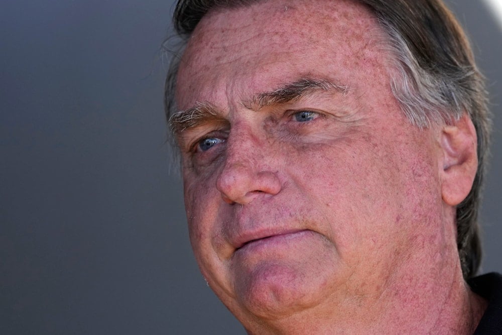 Former Brazilian President Jair Bolsonaro talks with supporters during his arrival to the international airport in Brasilia, Brazil, July 5, 2024. (AP)