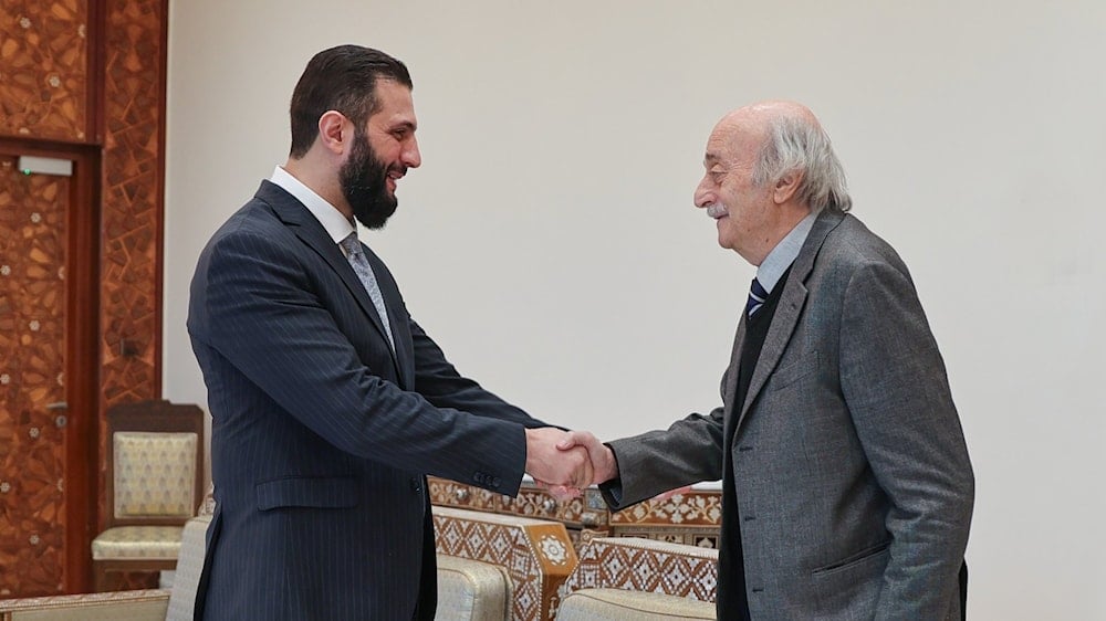 Former Head of the SSNP Walid Jumblatt shakes hands with the Interim President of Syria, Ahmad al-Sharaa, during their meeting at the People's Palace, Damascus, Syria (X/ @SyPresidency)