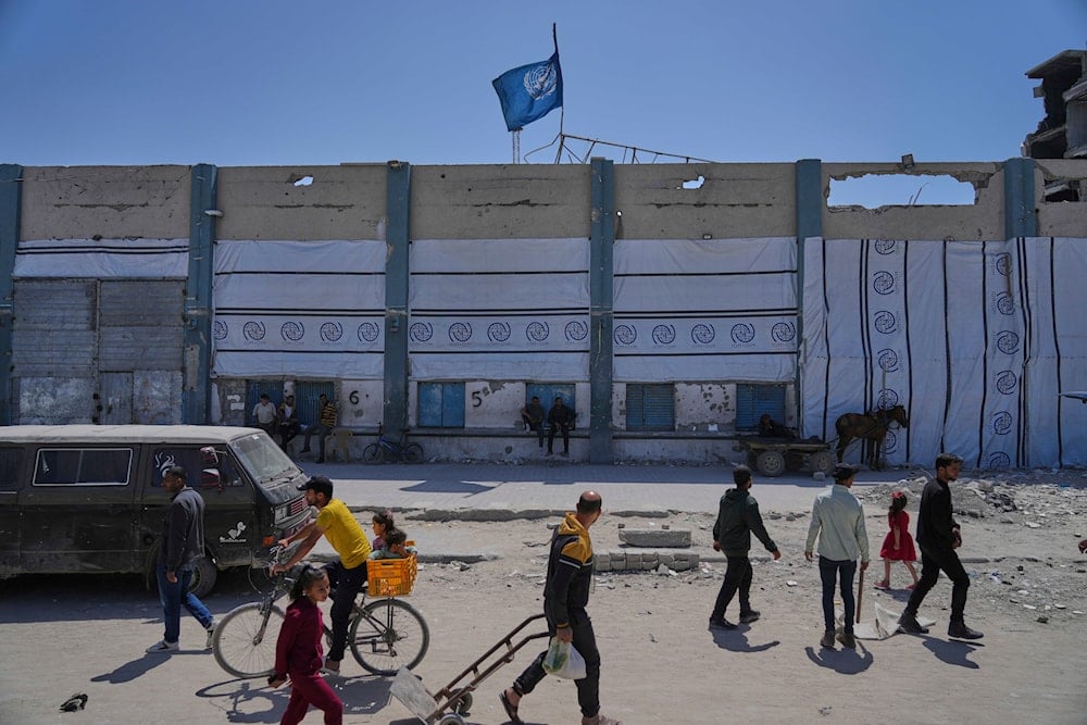 Palestinians walk next to the closed humanitarian aid distribution center of UNRWA, the U.N. agency helping Palestinian refugees in Jabaliya, Gaza Strip on April 29, 2025. (AP Photo/Jehad Alshrafi)