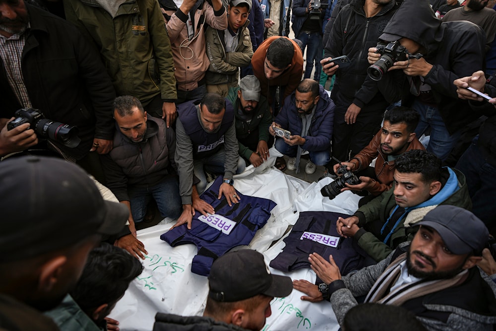 Palestinians, mostly journalists, gather around the bodies of five Palestinian journalists who were killed by an Israeli airstrike in Gaza City, at the Al-Aqsa Hospital in Deir al-Balah, Thursday, Dec. 26, 2024 (AP)