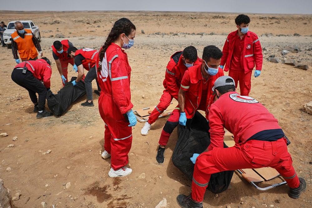 Syrian Red Crescent workers collect bodies off a highway of a convoy of Syrians from the Druze community who were heading from the southern Sweida province towards the capital, southern Syria, Thursday, May 1, 2025. (AP)
