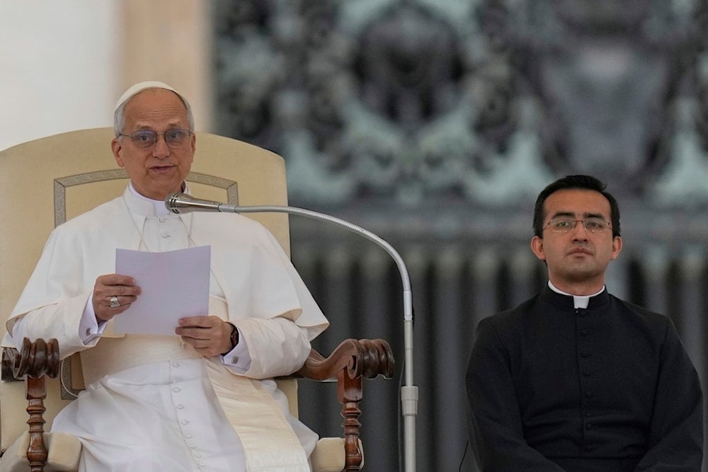 Pope Leo XIV is flanked by Father Edgard Iván Rimaycuna Inga during his first weekly general audience in St. Peter's Square at The Vatican, Wednesday, May 21, 2025. (AP Photo/Gregorio Borgia)