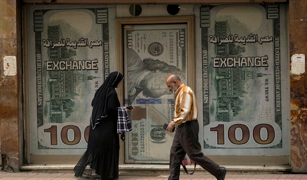 Egyptians walk past an exchange office in Cairo, Egypt, Wednesday, March 6, 2024. (AP)