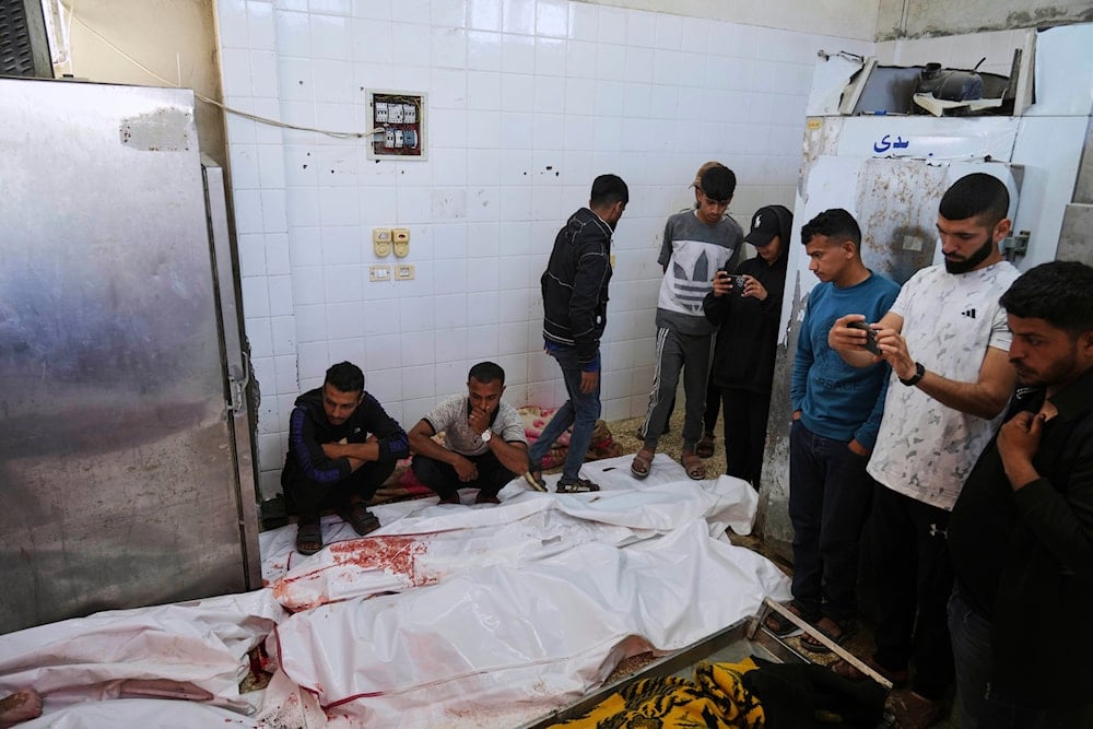 Palestinian mourn their relatives who were killed in an Israeli airstrike on the Gaza Strip, at the morgue of Al-Aqsa Hospital in Deir al-Balah, Gaza, Thursday, May 22, 2025 (AP)
