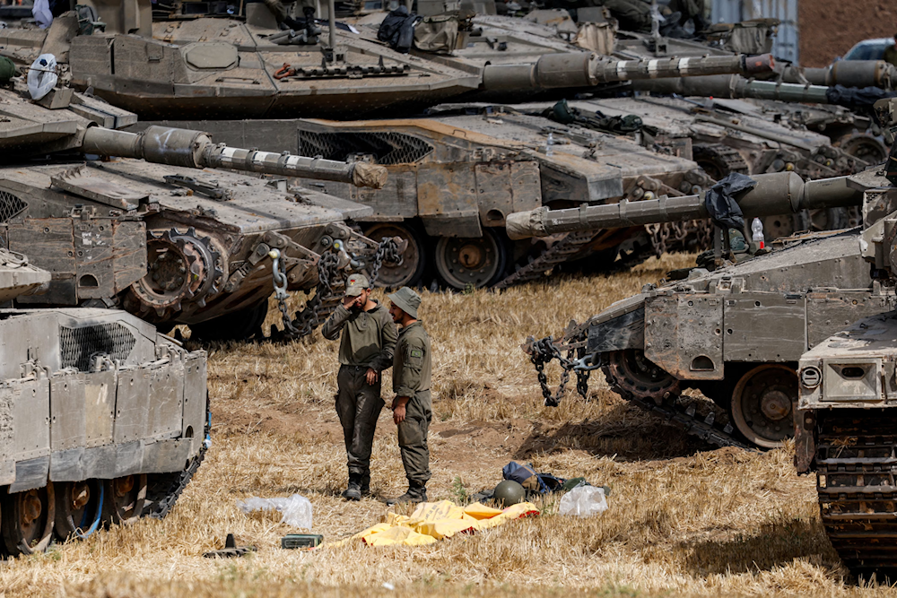 Israeli occupation forces near military vehicles at the Gaza border (AP)