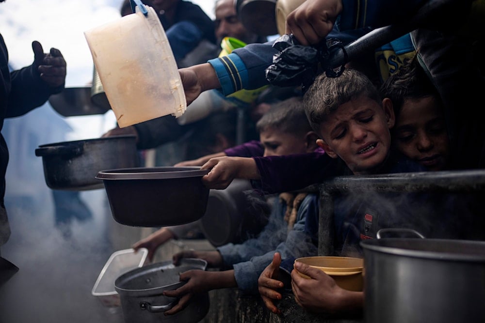 Palestinians line up for a meal in Rafah, Gaza Strip, Friday, Feb. 16, 2024 amid Israeli blockade and relentless bombing (AP)