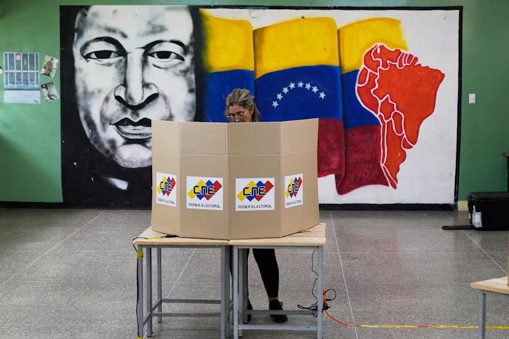 A voter marks her ballot and candidate in legislative and local elections in Caracas, Venezuela, Sunday, May 25, 2025. (AP)
