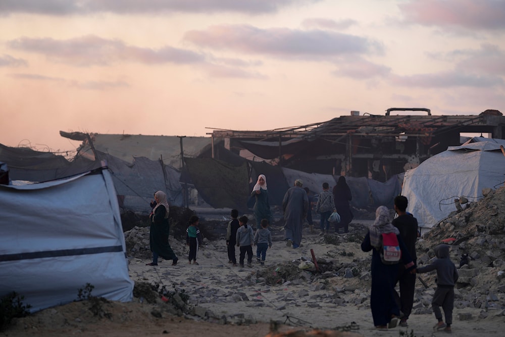 Forcibly displaced Palestinians walk through a makeshift tent camp at the port of Gaza City on Thursday, May 22, 2025. (AP)