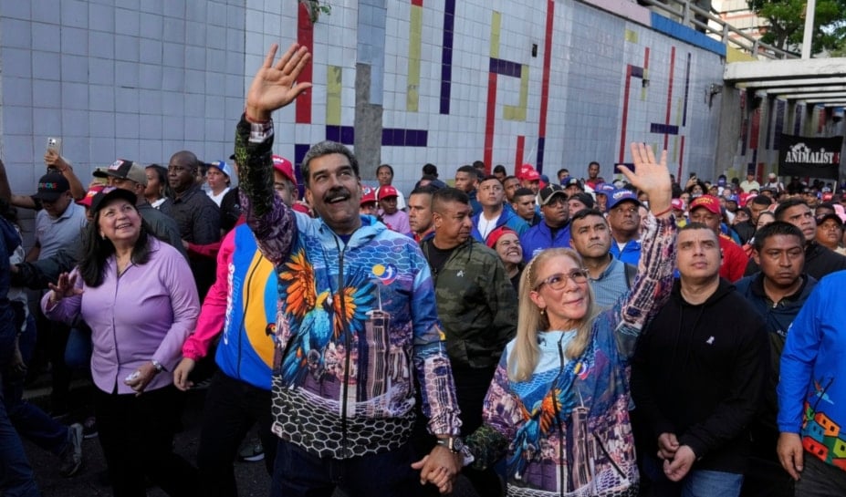 Venezuelan President Nicolas Maduro, center, and first lady Cilia Flores gesture to supporters during a closing campaign rally for the regional election on May 25, in Caracas, Venezuela, Thursday, May 22, 2025. (AP)