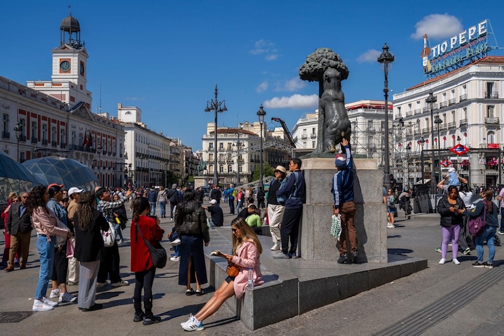 Tourists take snapshots in the Puerta del Sol square in downtown Madrid, Spain, Monday, April 29, 2024. (AP Photo/Bernat Armangue)