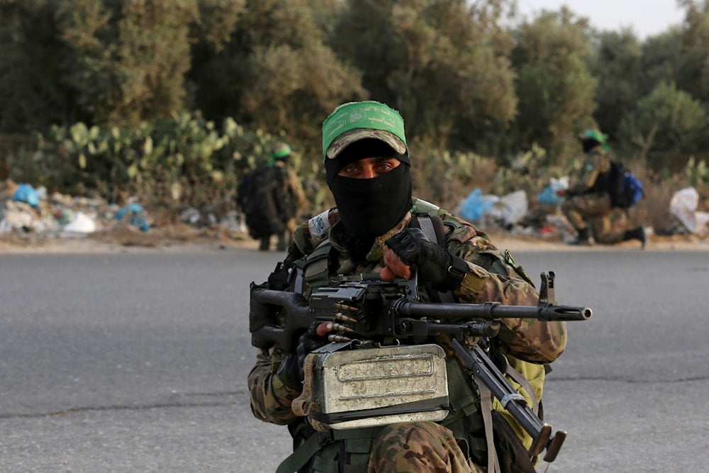 Masked militant from the Izzedine al-Qassam Brigades, a military wing of Hamas, takes position to secure his colleagues while marching along the main road of Nusseirat refugee camp, central Gaza Strip, Thursday, Oct. 28, 2021 (AP)