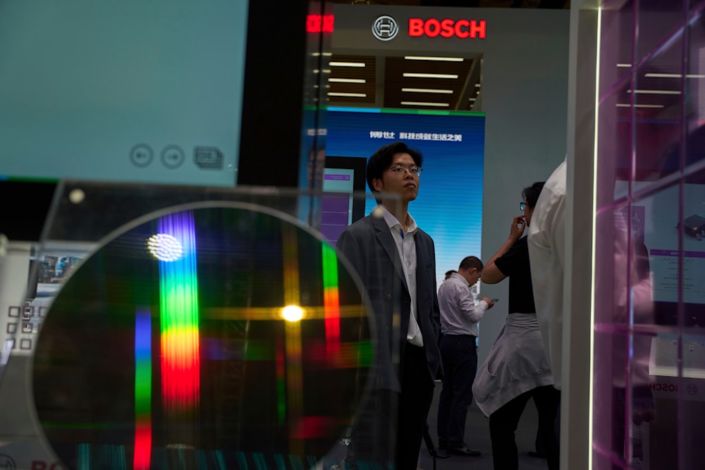 A visitor past by a semiconductor wafer displayed at the booth for Bosch during the Shanghai auto show on Thursday, April 24, 2025. (AP)