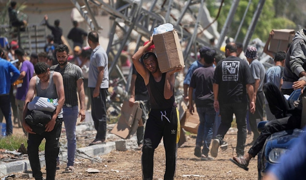 Palestinians carry boxes and bags containing food and humanitarian aid packages delivered by the Gaza Humanitarian Foundation in Khan Younis, southern Gaza Strip, on Thursday, May 29, 2025. (AP)