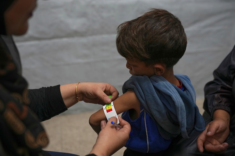A Palestinian boy is checked for signs of malnutrition by a nurse at a medical clinic in Gaza City amid the ongoing Israeli genocide, Wednesday, May 28, 2025. (AP)