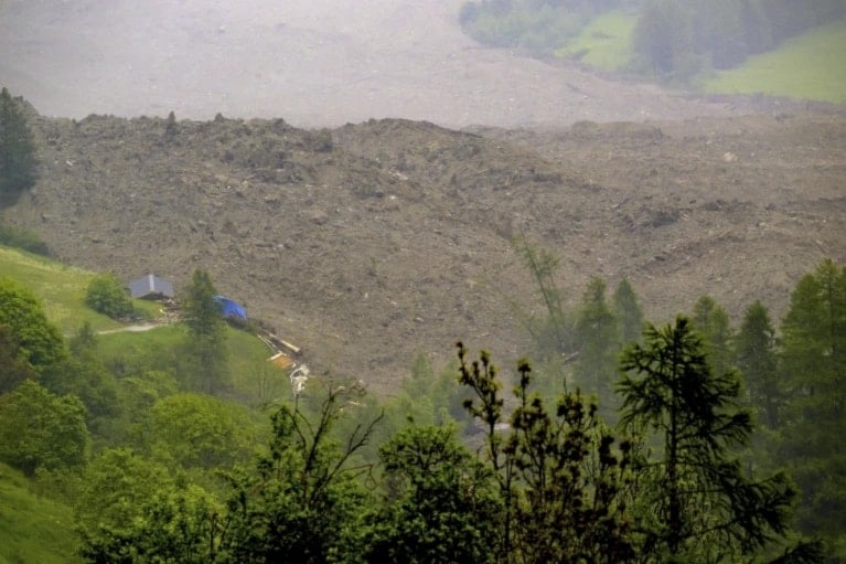 A large avalanche with a mixture of ice, rock snow and water reach the valley floor is pictured in Wiler after the Birch glacier collapsing above Blatten, switzerland. May 28, 2025 (Jean-Christophe Bott/Keystone via AP)
