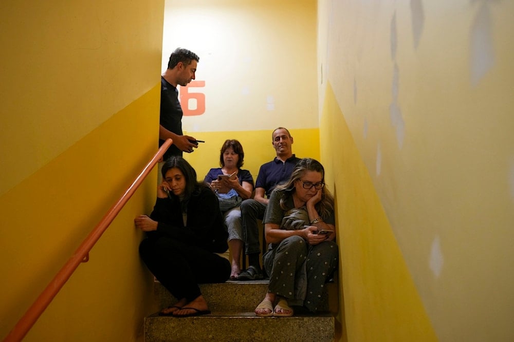 People take shelter as a siren sounds a warning of incoming rockets from Lebanon, Friday, November 22, 2024, in Haifa, occupied Palestine (AP)