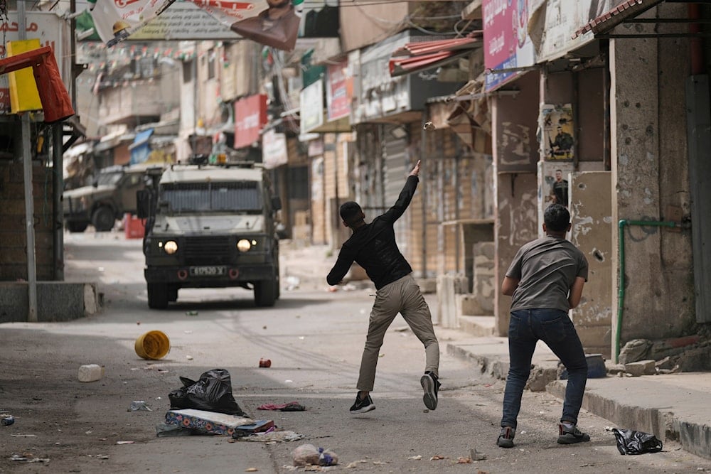 Palestinians hurls a stone at Israeli forces following a military raid in the West Bank refugee camp of Balata, on Wednesday, April 9, 2025 (AP)