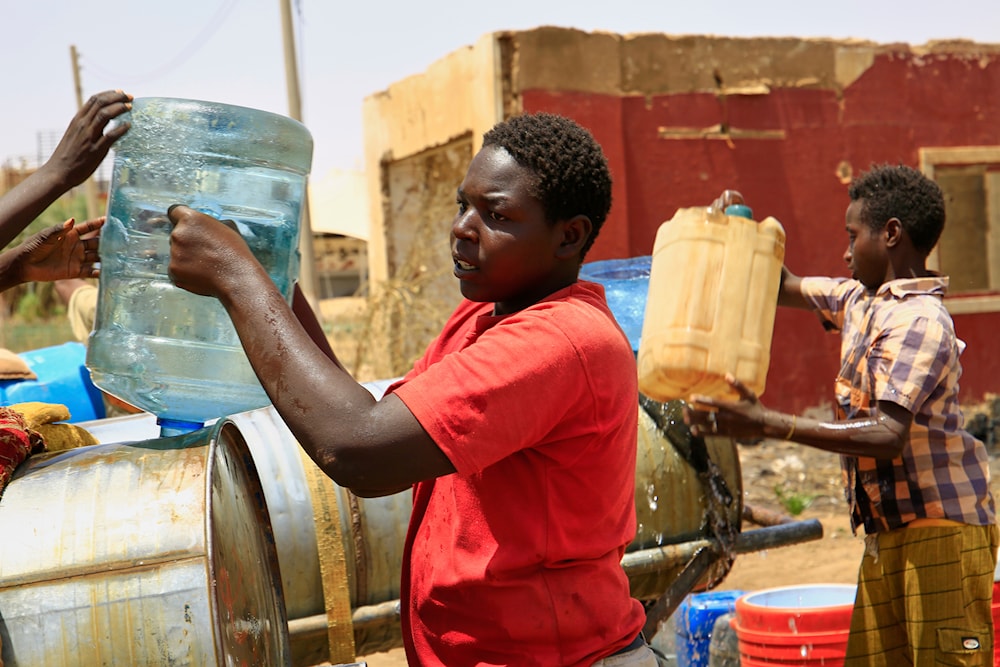 People fill a container by water due to water outages in Khartoum, Sudan, Sunday, May 25, 2025 (AP)