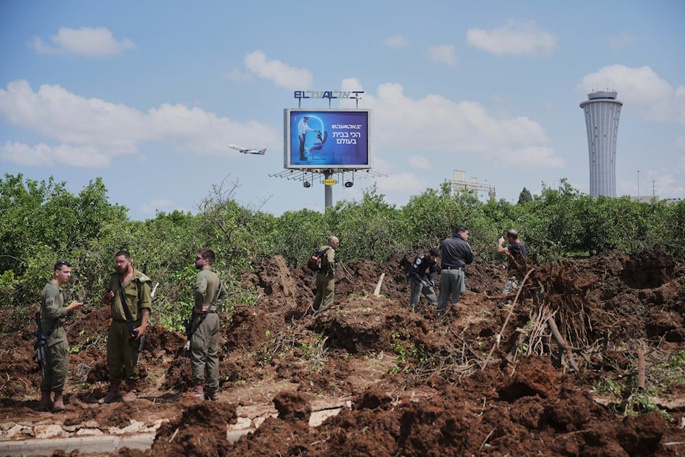 Israeli security forces inspect the site where the Israeli military said a projectile fired by Yemen's Ansar Allah landed in the area of Ben Gurion International Airport near Tel Aviv, Occupied Palestine on Sunday, May 4, 2025 (AP)
