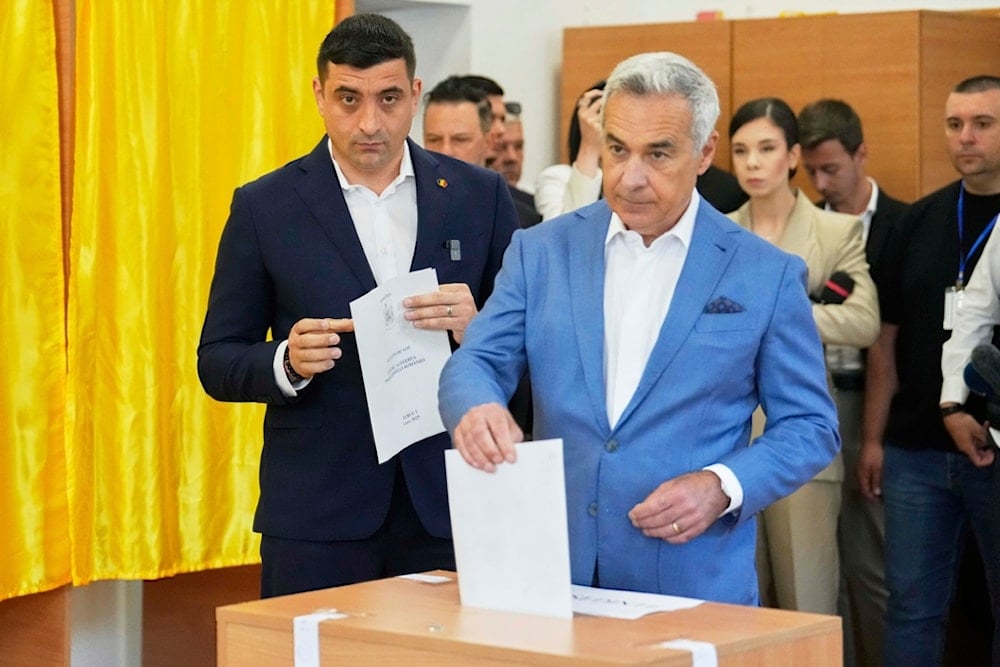 Calin Georgescu, winner of the first round of last year's annulled election, right, and Presidential candidate George Simion cast their votes in the first round of the presidential election redo in Mogosoaia, Romania, Sunday, May 4, 2025 (AP)