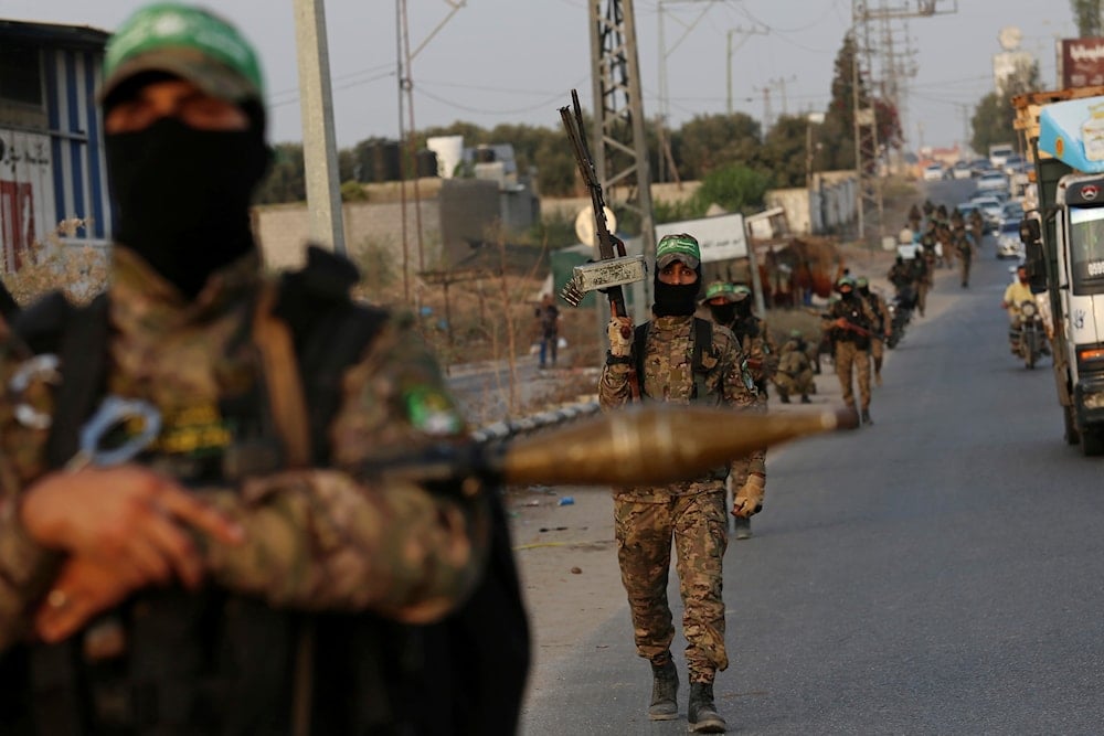 Masked fighters from the Ezzedine al-Qassam Brigades, a military wing of Hamas, march with their weapons along the main road of Nusseirat refugee camp, central Gaza Strip, Thursday, Oct. 28, 2021 (AP)