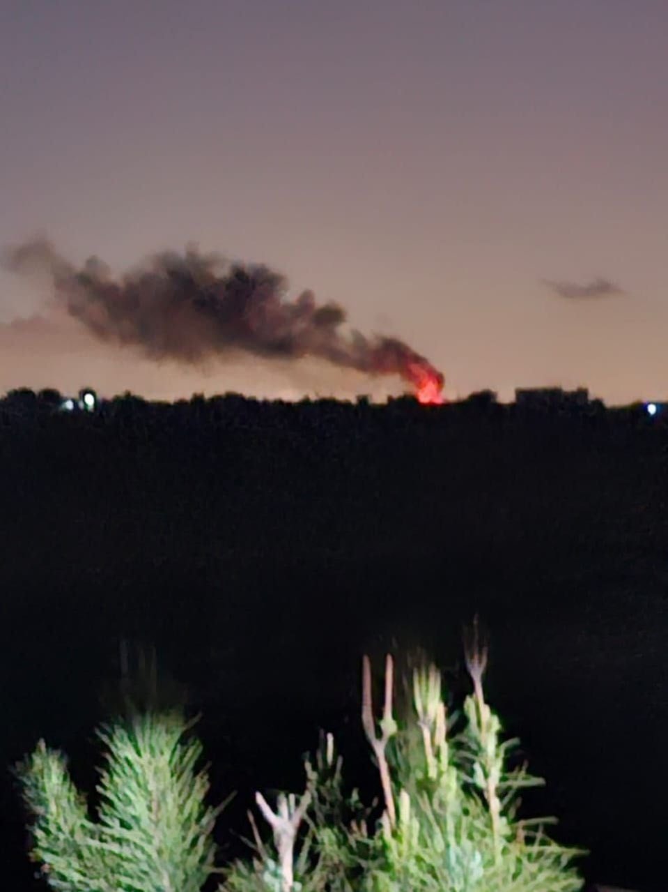 Fire is seen in the distance in Tayr Harfa, Southern Lebanon, following an Israeli airstrike, May 5, 2025 (Social Media)