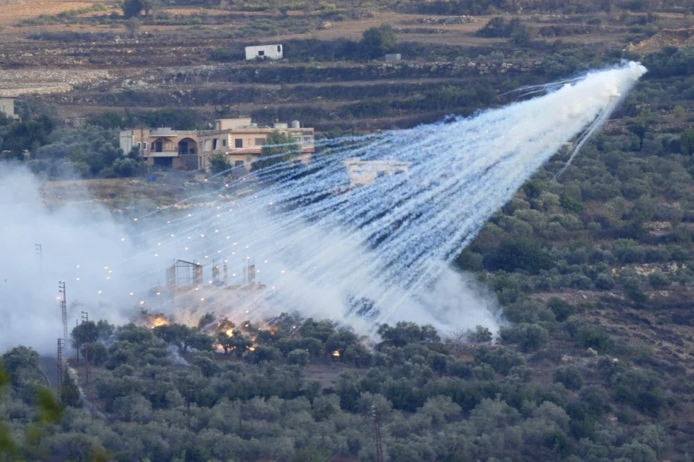 A shell that appears to be white phosphorus from Israeli artillery explodes over a house in al-Bustan, a Lebanese village along the border with 