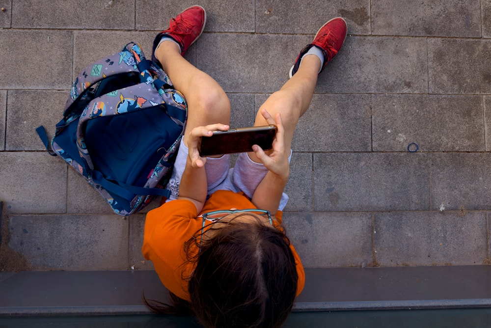  A 12-year-old boy plays with his personal phone outside school in Barcelona, Spain, Monday, June 17, 2024. (AP)