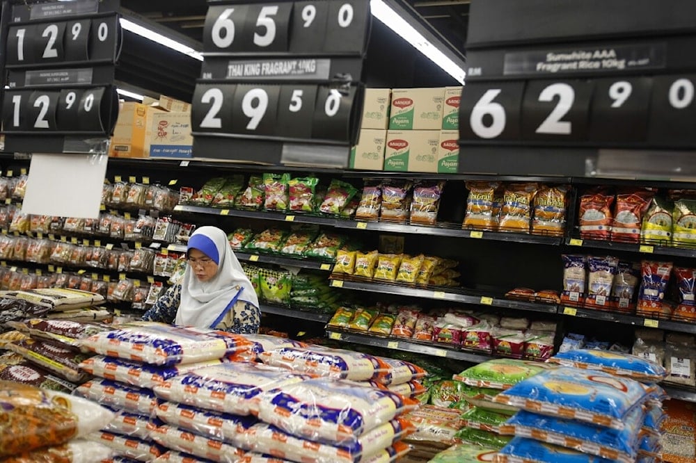 A Malaysian Muslim woman checks on rice grain in a mall outside Kuala Lumpur, Malaysia on August 18, 2015 (Joshua Paul/AP)