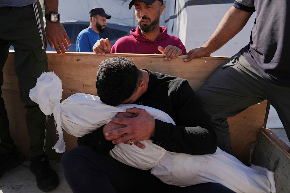 A Palestinian man embraces the body of his 5-year-old son, Adam Namrouti, who was killed in an overnight Israeli airstrike on a UN school,at Al-Aqsa Hospital in Deir al-Balah, in the central Gaza Strip, Wednesday, May 7, 2025
