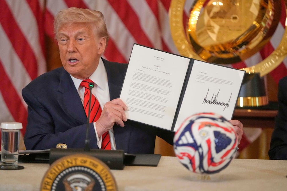 President Donald Trump holds the signed charter for the 2026 FIFA World Cup task force in the East Room of the White House, Tuesday, May 6, 2025, in Washington (AP)