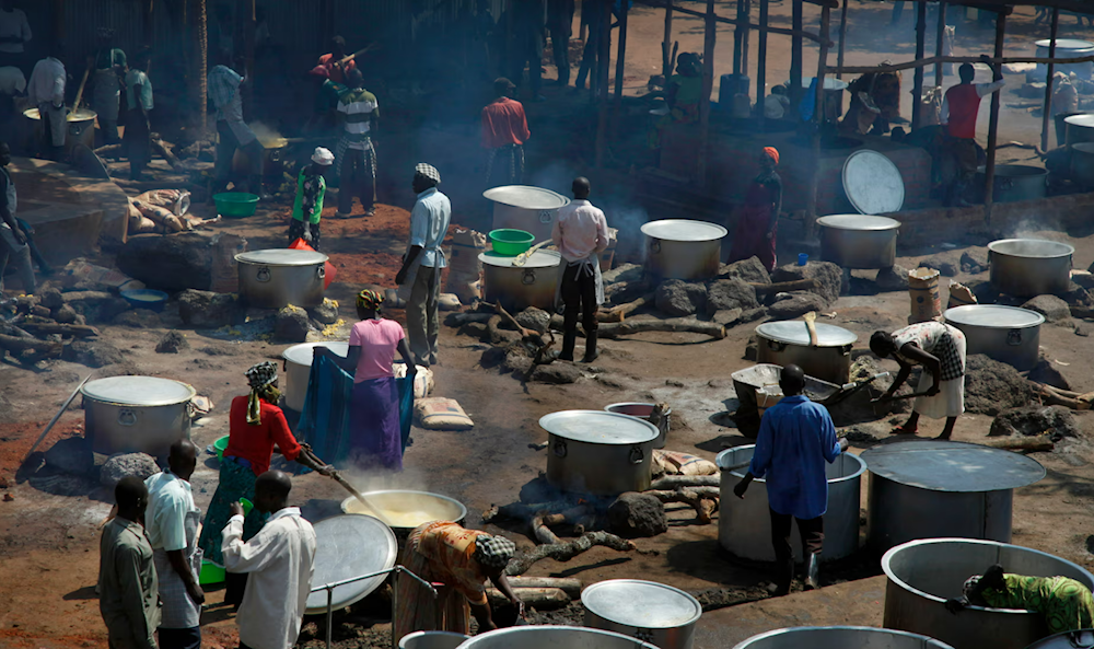 People cook maize porridge, known locally as posho, donated by USAID at Uganda’s Bidi Bidi camp, one of Africa’s largest with more than 250,000 refugees (Stephen Wandera/AP)