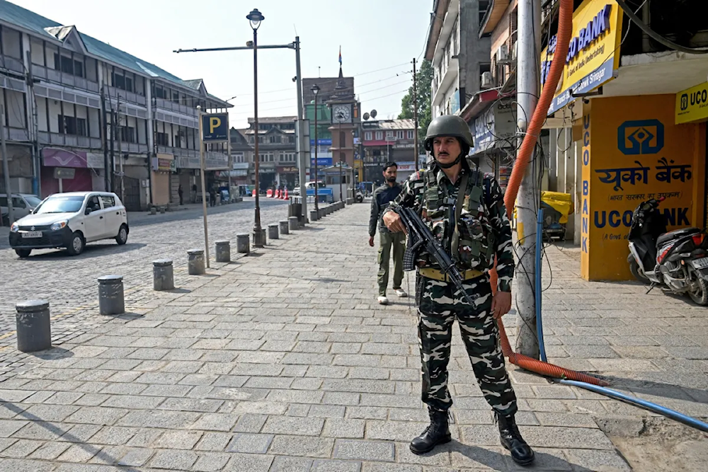 An Indian soldier stands guard near closed stores in Srinagar, Kashmir, on May 8 (Tauseef Mustafa/AFP)