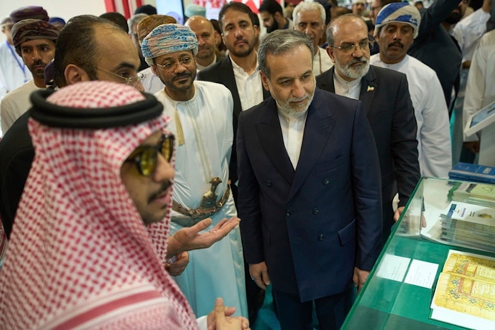 Iranian Foreign Minister Abbas Araghchi, center right, and Omani Foreign Minister Badr al-Busaidi, center left, walk through the Muscat International Book Fair in Oman, Friday, April 25, 2025 (AP)