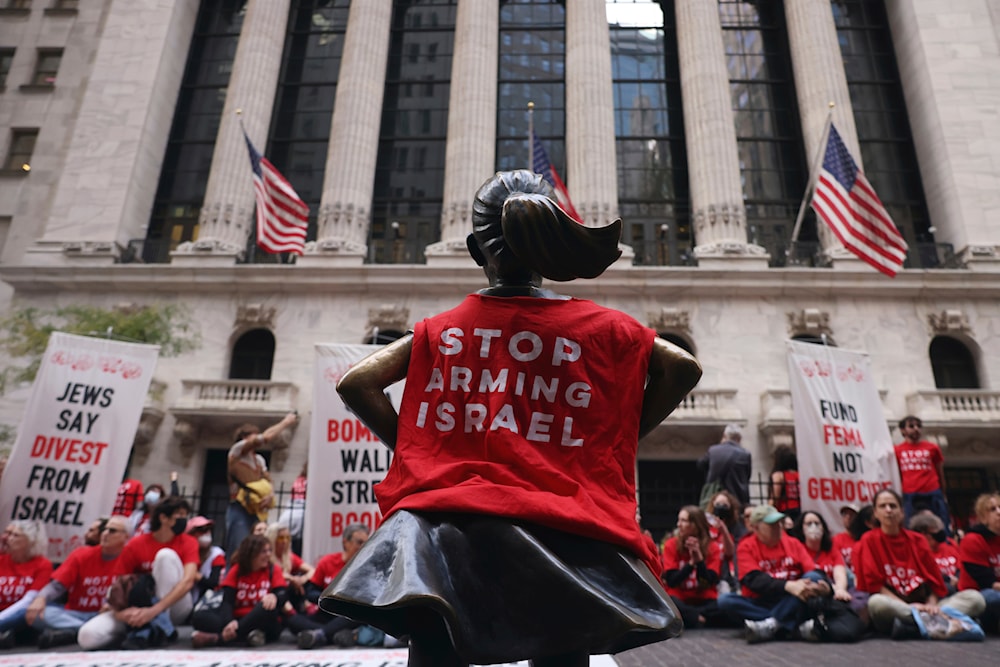 The Fearless Girl statue wears a pro-Palestinian protesters' shirt as they sit in front of the New York Stock Exchange, Monday, Oct. 14, 2024, New York. (AP)