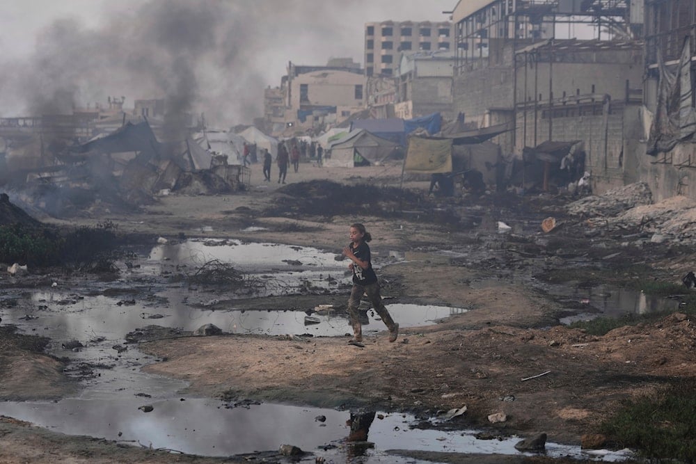 A Palestinian girl runs past the ruins of destroyed buildings along the Gaza City shoreline on Monday, June 9, 2025. (AP Photo/Jehad Alshrafi)