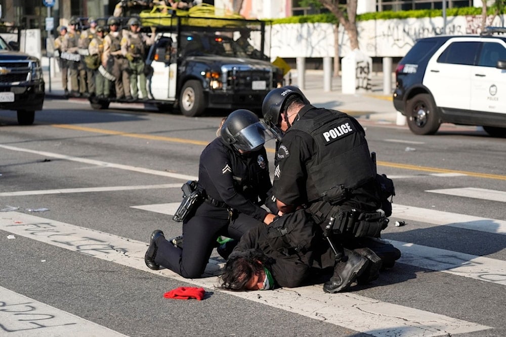 A Los Angeles police officers arrest a protester in downtown Los Angeles on Monday, June 9, 2025 (AP)