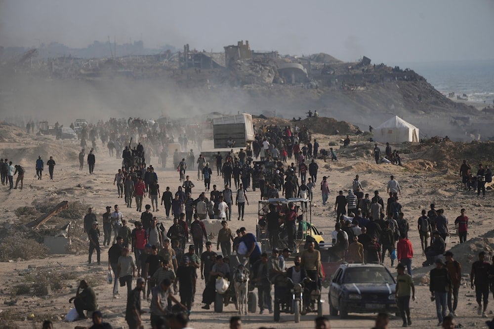 Forcibly displaced Palestinians walk past the ruins of destroyed buildings by Israeli airstrikes along the Gaza City shoreline on Monday, June 9, 2025. (AP)