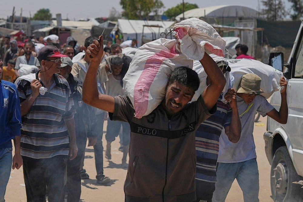 A Palestinian carries a bag containing food and humanitarian aid delivered by the Gaza Humanitarian Foundation, a US-backed organization, in Rafah, southern Gaza Strip, Wednesday, June 11, 2025 (AP)