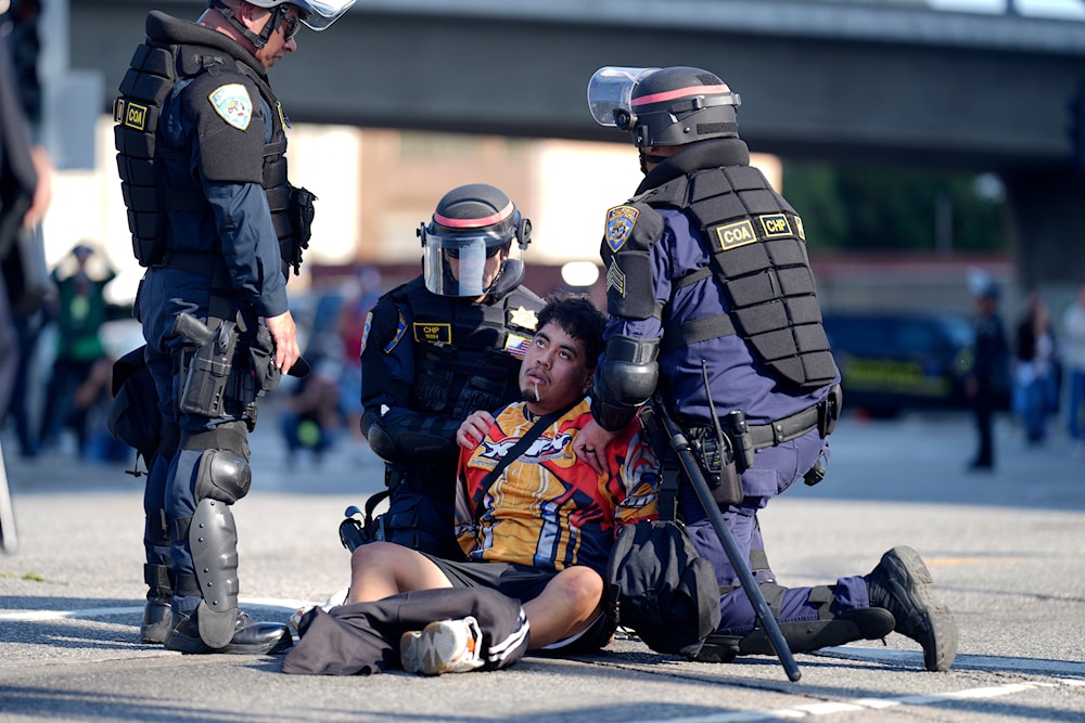 A protester is arrested by by law enforcement officers in downtown Los Angeles near the federal building on Tuesday, June 10, 2025. (AP Photo/Eric Thayer)