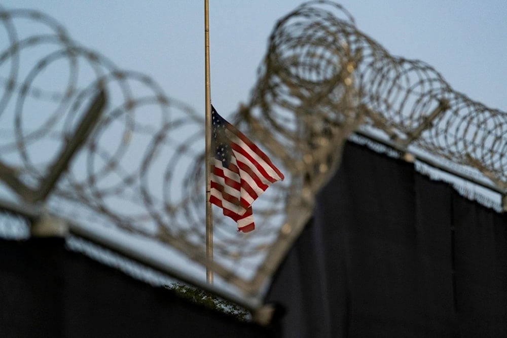 In this Aug. 29, 2021, photo reviewed by US military officials, a flag flies at half-staff as seen from Camp Justice in Guantanamo Bay Naval Base, Cuba. (AP Photo/Alex Brandon, File)