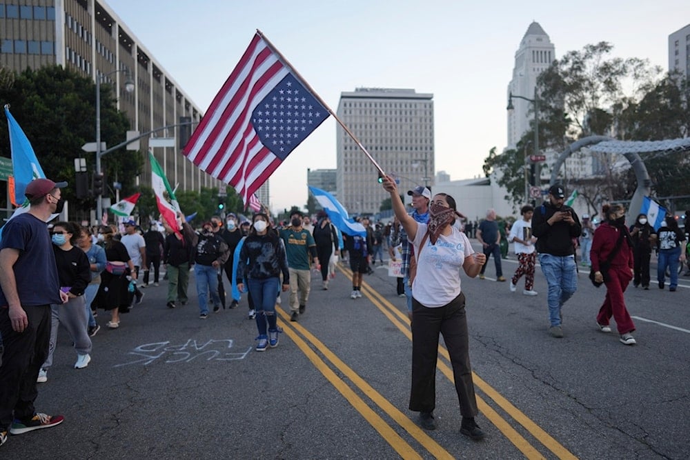 Protesters listen to speakers as California National Guardsmen stand in line on Tuesday, June 10, 2025, in Los Angeles. (AP Photo/Eric Thayer)