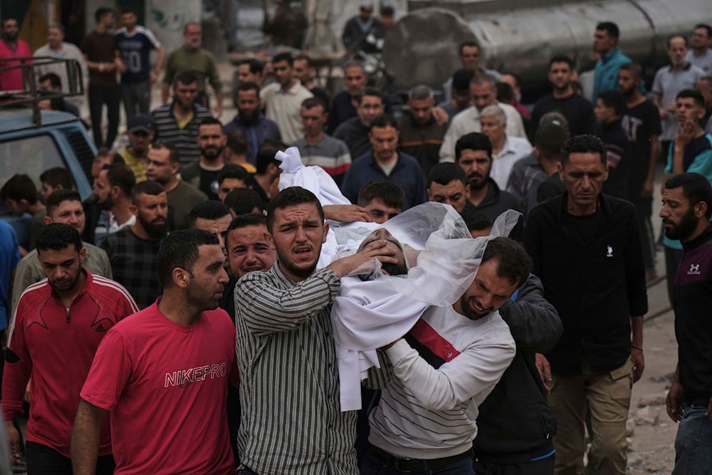 Mourners carry the body of a Palestinian for burial after the person was killed in an Israeli military airstrike that hit a U.N. school, in Jabaliya, northern Gaza Strip, on May 12, 2025. (AP Photo/Jehad Alshrafi)