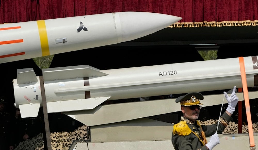 Missiles are carried on a truck as an Iranian army band leader conducts the music band during the Army Day parade at a military base in northern Tehran, Iran, Wednesday, April 17, 2024 (AP)
