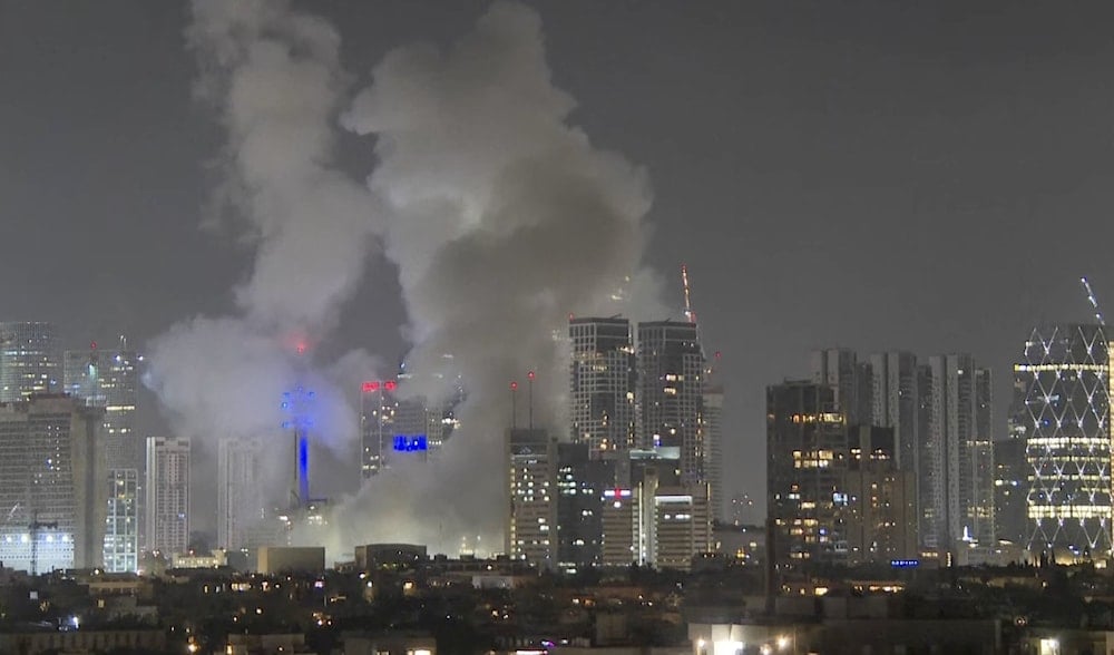 Smoke rises after an Iranian ballistic missile directly struck Tel Aviv, Occupied Palestine, June 13, 2025 (AP)