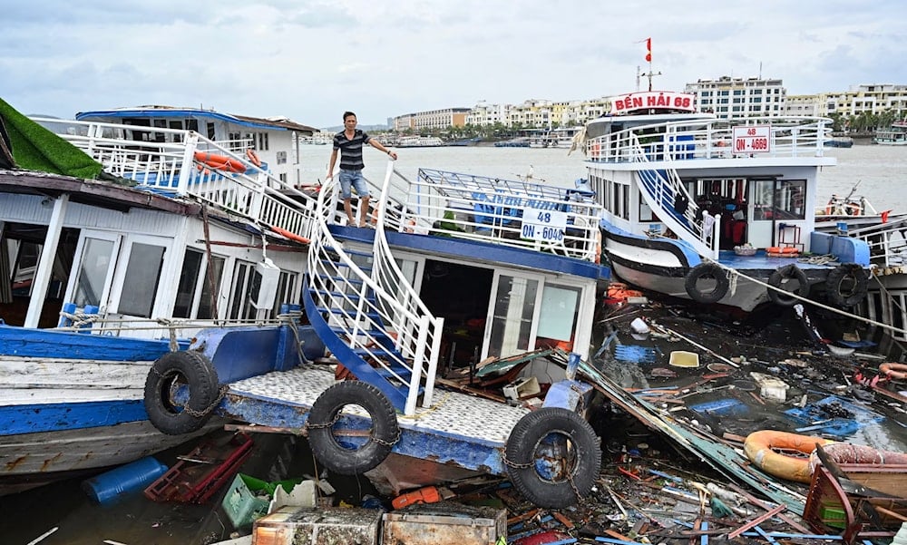 A man checks his damaged boat after Typhoon Yagi hit Ha Long Bay (Nhac Nguyen/AFP)